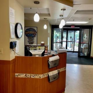 A welcoming reception area featuring a wooden front desk and modern lighting.