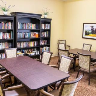 A library meeting room with bookshelves, tables, and chairs.