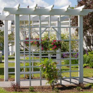 A white pergola with a trellis, adorned with hanging flowers in a garden setting.