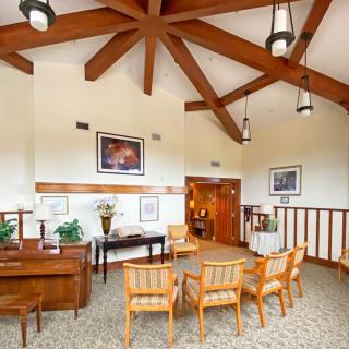 A cozy waiting room with wooden beams, comfortable chairs, and warm lighting.
