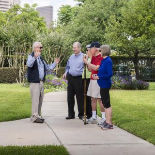 A group of people enjoying a conversation in a park on a pleasant day.