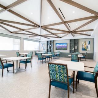 A modern dining area with stylish furniture and geometric ceiling design.