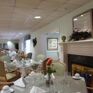 A beautifully arranged dining room featuring elegant tables and floral decorations, creating a warm and inviting atmosphere.