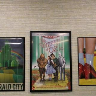 A trio of 'The Wizard of Oz' themed posters displayed on a wall.