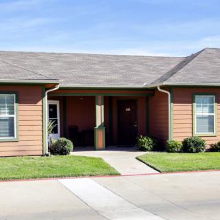A suburban home with a front porch and neatly trimmed lawn.