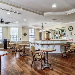 A cozy cafe interior with tables, chairs, and a bar area.
