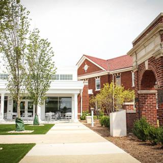 A modern brick building with a landscaped entrance and walkway.