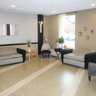 A modern lobby featuring comfortable seating, a coffee table, and ample natural light.
