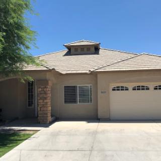 A charming single-story house with a garage and well-maintained front yard.