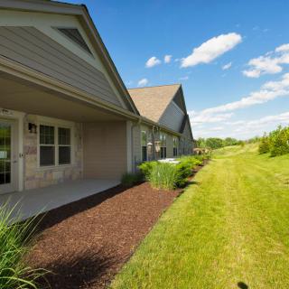 A sunny day in a suburban backyard with a well-maintained lawn and garden.