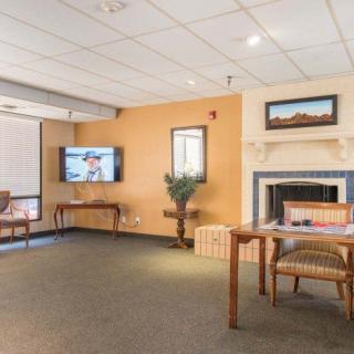 A cozy living room with a television mounted on the wall, a fireplace, and comfortable seating.