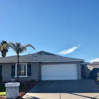 A charming single-family home with a garage, set against a backdrop of clear blue skies.