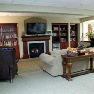 A cozy living room with a fireplace, television, and bookshelves.