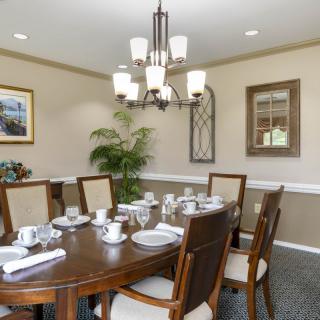 A well-appointed dining room featuring a wooden table, elegant chairs, and a stylish chandelier.