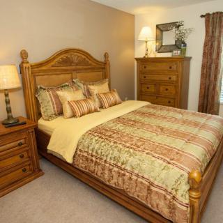 A cozy bedroom with wooden furniture and warm decor.