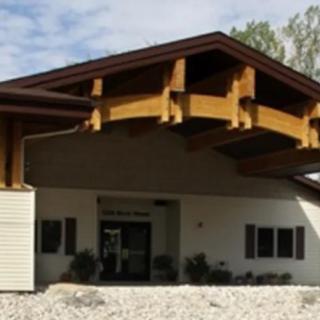 A modern building with a distinctive wooden roof structure at the entrance.