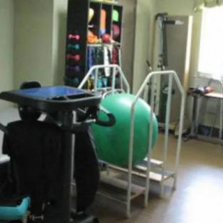 A room equipped with exercise and physiotherapy equipment, including a large therapy ball.