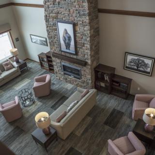 A spacious living room with a stone fireplace, cozy seating arrangements, and stylish interior design.