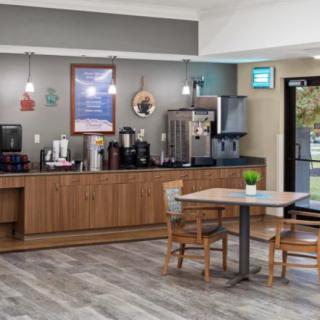 A cozy coffee station with wooden furniture and a seating area in an inviting interior setting.