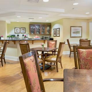 A cozy dining area with wooden tables and chairs in a well-lit interior.