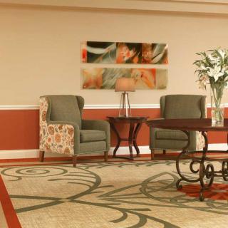 A lobby area with comfortable chairs, a decorative table, and artwork on the wall.