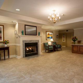 A cozy living room featuring a fireplace, chandelier, and comfortable seating area.