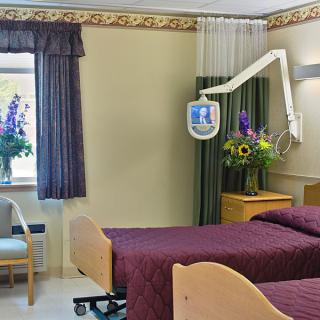 A hospital room with two beds and medical equipment.
