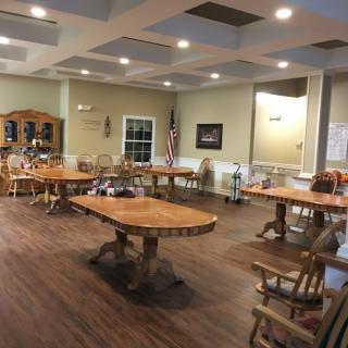 A spacious meeting room with wooden tables and chairs, decorated with an American flag and various items.