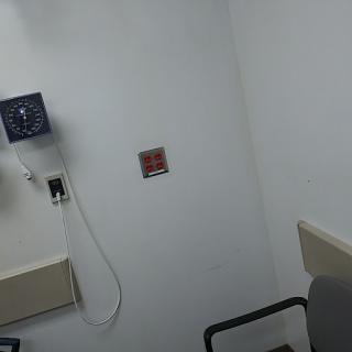 A view of a hospital room featuring medical equipment and a chair.