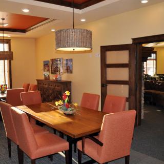 A well-decorated dining room featuring a wooden dining table, upholstered chairs, and a stylish chandelier.