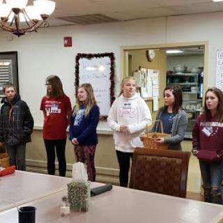 A group of young individuals standing together in a meeting room.