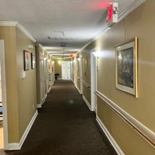 A brightly lit interior hallway with artwork on the walls.