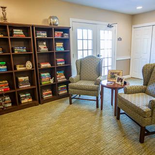 A cozy reading room with bookshelves and comfortable chairs.