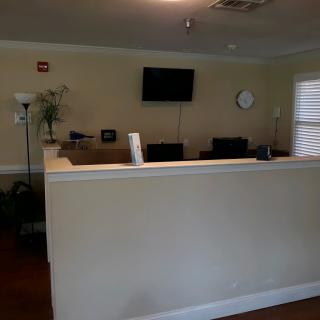 Reception area with a desk, television, and clock on the wall.