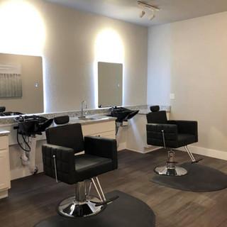 Modern barbershop interior with styling chairs and mirrors.