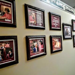 A collection of framed photographs displayed on a wall, showcasing various images in a gallery-style arrangement.