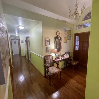 A cozy hallway with a wooden floor, featuring elegant furniture and decorated walls.