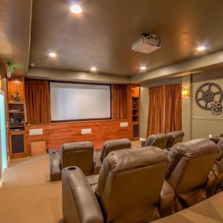 A cozy home theater setup with comfortable recliner seating and a large projection screen.