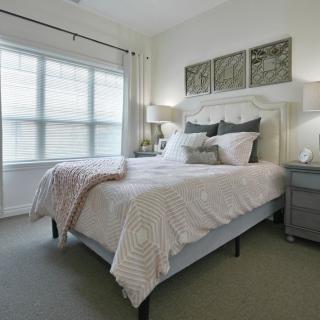 A cozy and stylish bedroom with a comfortable bed, elegant nightstands, and soft lighting.