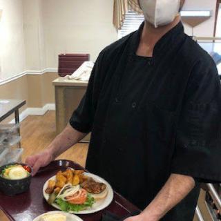 A chef serving a delicious meal in a kitchen.