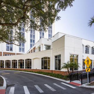 A modern hospital building with a well-designed exterior and surrounding trees.