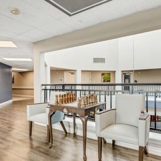 A modern interior space featuring a table and chairs in an open area with natural lighting.