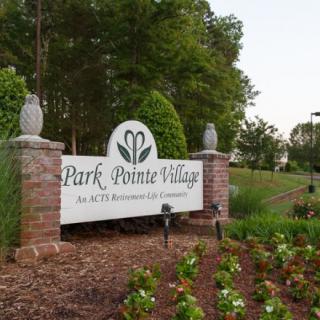 Entrance sign to Park Pointe Village surrounded by landscaped gardens.