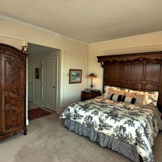A cozy bedroom featuring vintage wooden furniture and a comfortable bed.