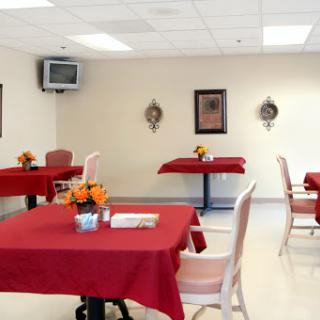 A cozy dining area featuring tables with red tablecloths and decorative elements.