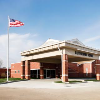 A modern healthcare facility featuring an American flag in front.