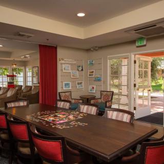 A well-lit conference room with a large table and chairs, featuring decorated walls and natural light from the windows.