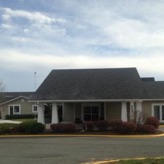 A suburban residential building with a sloped roof and landscaped surroundings.