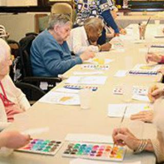 A group of seniors participating in an art activity at a community center.