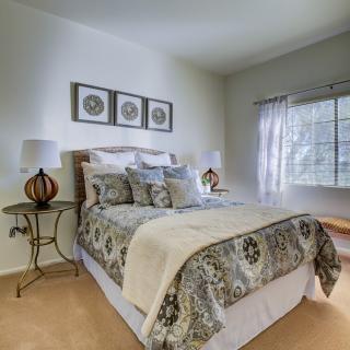 A cozy and elegantly decorated bedroom with a neatly made bed and stylish furnishings.
